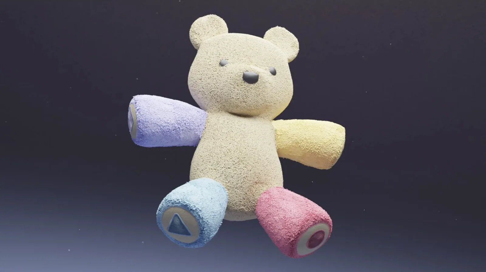 The finalized Baloo bear photographed against a dark background, showing the complete physical product with the four colored limbs and shape symbols fully realized